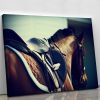 Saddle with stirrups on a back of a brown horse Canvas Print or Poster